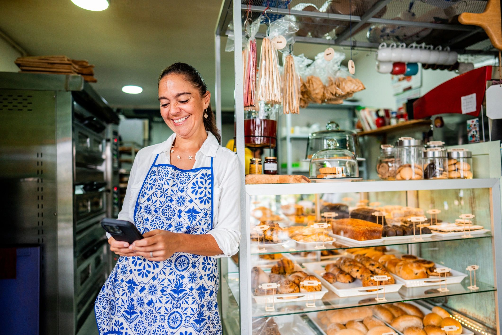Small business owner using a phone to manage online promotion